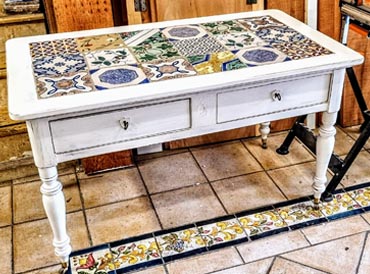 Tavolo restaurato con piastrelle colorate in stile artigianale